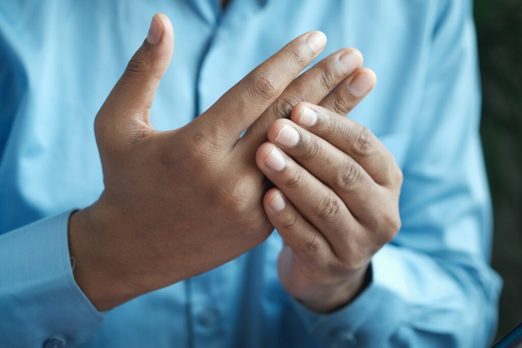 person in blue shirt showing left hand